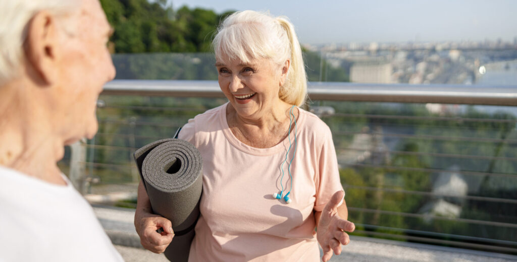 senior lady with mat and earphones talks to man on 2025 03 13 07 11 56 utc scaled e1752770554161