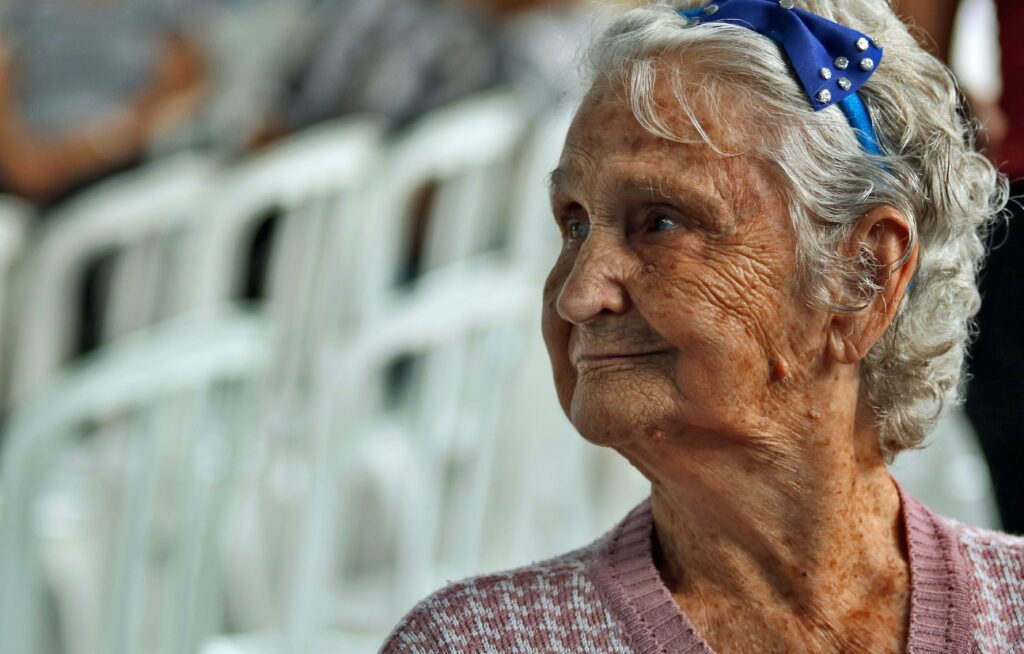 Elderly woman with stylish blue accessory.