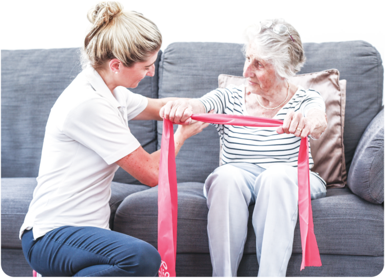 Physiotherapist from The Well Balanced Centre helping an elderly client with a resistance-band exercise during a home physiotherapy session in Haywards Heath, West Sussex