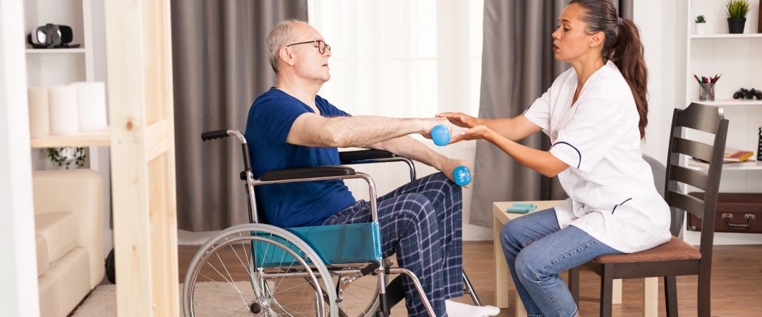Disabled old man during physiotherapy talking with doctor about his pain. Disabled handicapped old person with social worker in recovery support therapy physiotherapy healthcare system nursing retirement home